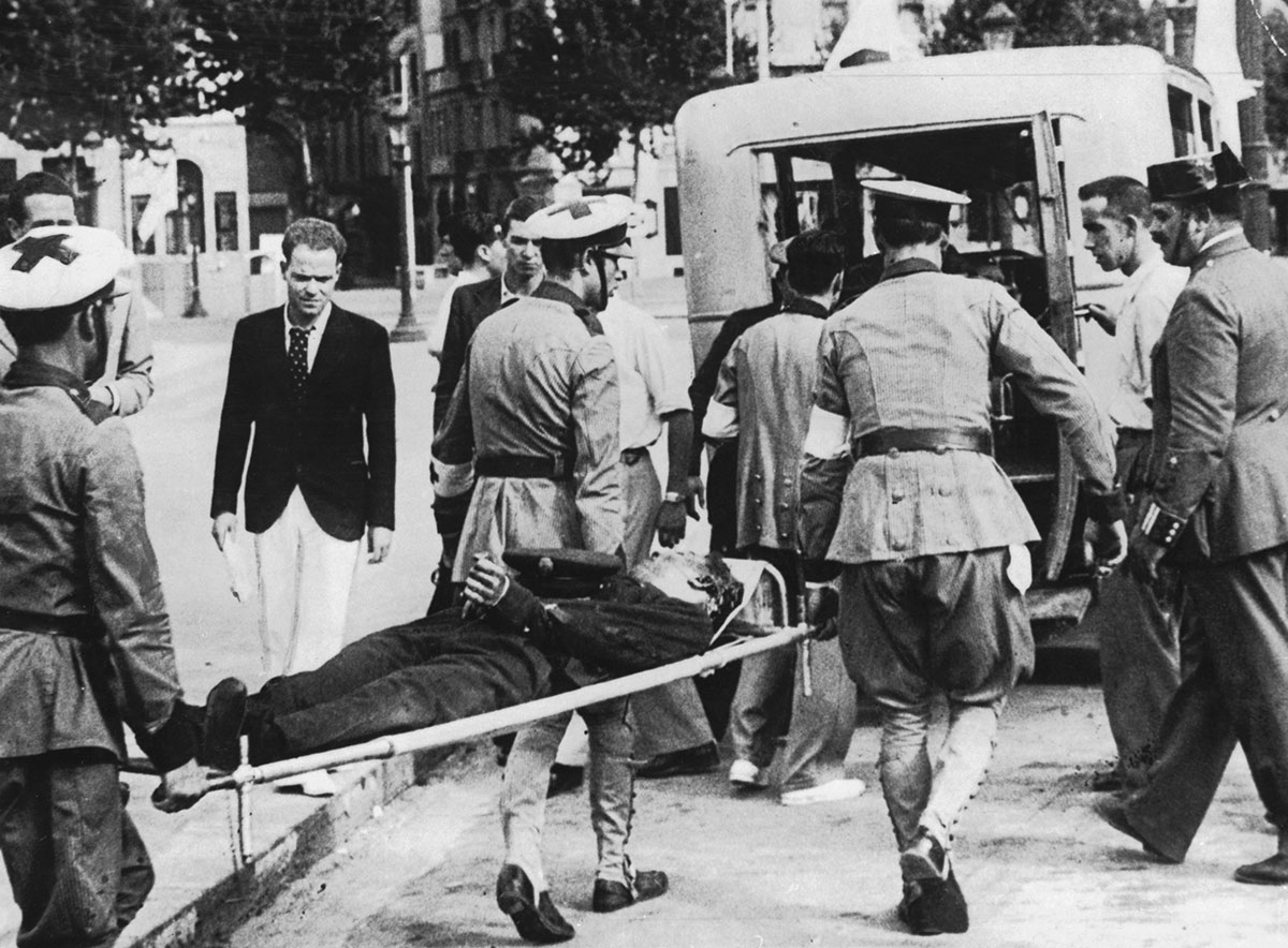 Camilleros de Cruz Roja trasladan a una víctima de los primeros enfrentamientos callejeros en la Guerra Civil. Barcelona, 24 de julio de 1936.